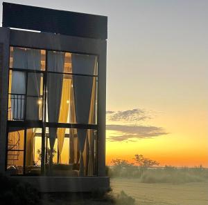 a building with a sunset in the background at Ita Pora Lodge in Bella Vista
