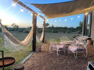 a patio with hammocks and a table and chairs at Ita Pora Lodge in Bella Vista