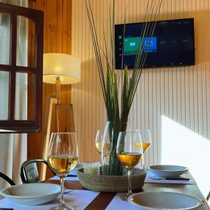 a table with wine glasses and a television on a wall at Fratelli Cabañas-Apart in Rosario