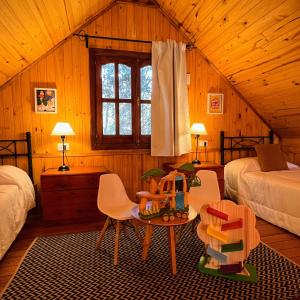 a bedroom with two beds and a table and chairs at Fratelli Cabañas-Apart in Rosario