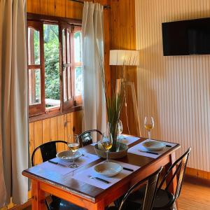 a wooden table with chairs and a vase on it at Fratelli Cabañas-Apart in Rosario