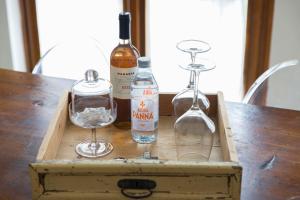 a wooden box with bottles and glasses on a table at Boutique Apartment Cà Tulles in Torri del Benaco