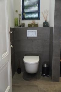 Un baño con inodoro blanco y ventana. en natural green loft, en Bergen