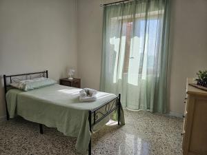 una camera da letto con un letto e una grande finestra di Tenuta degli Ulivi - Dimora Contadina a Montecorvino Rovella Altre 32 foto