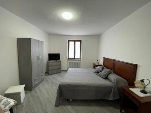 a bedroom with a large bed and a television at Affittacamere "Fratello Sole e Sorella Luna" in Greccio