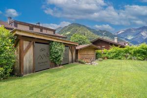 a house with a garage with a grass yard at Das Bergland - Vital & Activity in San Leonardo in Passiria