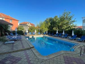 a swimming pool with blue chairs at ,,Дироси'' in Sveti Vlas