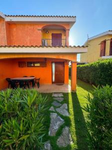 a house with a patio and a table in the yard at Villa Arianna - Porto Pino in SantʼAnna Arresi
