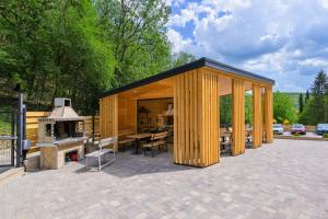 a wooden pavilion with a patio and a grill at Montebelo Villas in Veliko Tŭrnovo