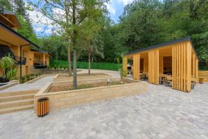 a pavilion with a wooden building in a courtyard at Montebelo Villas in Veliko Tŭrnovo