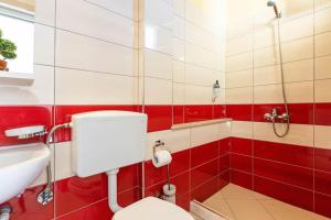 ein rot-weißes Bad mit einem WC und einem Waschbecken in der Unterkunft Potam'Sea Bliss 8 - Beach Front, Sun Beds & Parking in Himarë + 18 Fotos