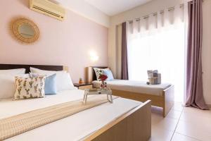 ein Hotelzimmer mit zwei Betten und einem Fenster in der Unterkunft Potam'Sea Bliss 8 - Beach Front, Sun Beds & Parking in Himarë