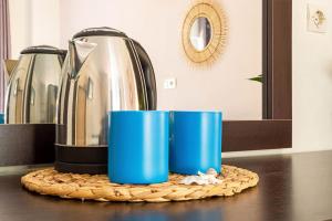 zwei blaue Tassen auf einer Theke mit einer Kaffeekanne in der Unterkunft Potam'Sea Bliss 8 - Beach Front, Sun Beds & Parking in Himarë