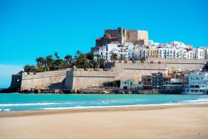 una playa frente a una ciudad con un castillo en Casas del Castillo Peñíscola-Intramuros Suites, en Peñíscola