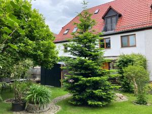 una casa con un árbol en el patio en Gästehaus Kesselshain, en Borna