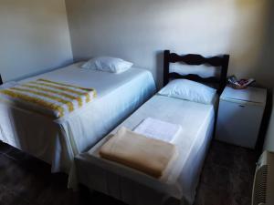 two beds sitting next to each other in a room at Gil's suites in Paraty