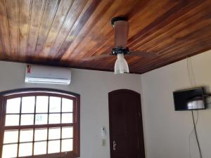 a ceiling fan and a television in a room at Gil's suites in Paraty +3 photos