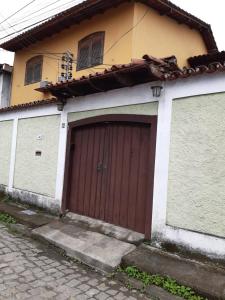 a house with a brown garage door on a street at Gil's suites in Paraty