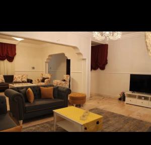 a living room with a couch and a tv at Quba luxury in Medina +9 photos