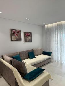a living room with a couch and blue pillows at Alpha Lux Apartment in Sarandë