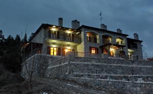 una casa con luces en la parte superior de una pared de piedra en Thisoa Hotel, en Karkaloú