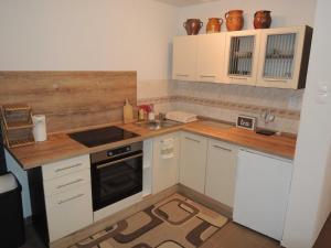 a small kitchen with white cabinets and a sink at Apartmán Viky in Hrabušice