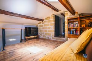 ein Wohnzimmer mit einer Couch und einer Steinwand in der Unterkunft Belle villa provençale - familiale - Grand terrain in Saint-Quentin-la-Poterie