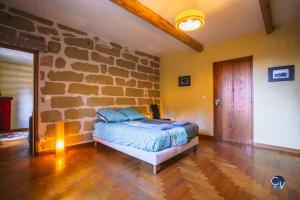 ein Schlafzimmer mit einem Bett und einer Steinwand in der Unterkunft Belle villa provençale - familiale - Grand terrain in Saint-Quentin-la-Poterie