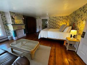 a bedroom with a bed and a couch and a table at The Harpswell Inn in Harpswell Center