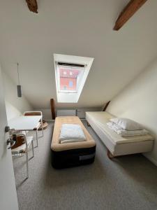 una stanza con due letti, un tavolo e una finestra di Cozy apartment room 1 - free parking in the street a Odense