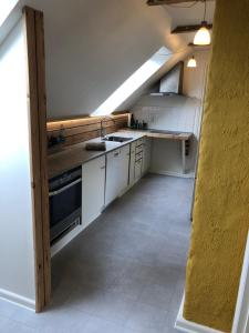 una cucina con armadi bianchi e lavandino di Cozy apartment room 1 - free parking in the street a Odense