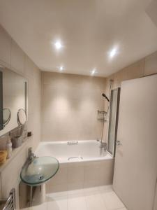 a bathroom with a bath tub and a sink at Cavaye house in London +19 photos