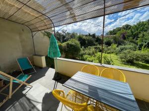 ein Tisch und Stühle auf einem Balkon mit Aussicht in der Unterkunft Gîte avec terrasse in Saint-Saturnin