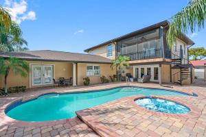 a house with a swimming pool in front of a house at Luxury Heated Pool Spa Villa with Game Room & More! in Tampa