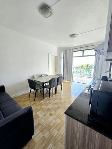 Una sala de estar con una mesa y sillas y un sofá. en Luxury Penthouse with Infinity Pool & Stunning Sea View, en Flic en Flac 3 fotos más