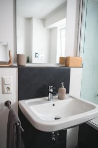 a bathroom with a white sink and a mirror at Traumwohnung im Kölner Süden in Hürth +22 photos