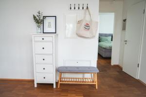 a bedroom with a chair and a dresser with a bag at Traumwohnung im Kölner Süden in Hürth