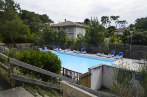 una piscina con tumbonas y una valla en OSoleMio Moliets, en Moliets-et-Maa