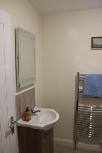 ein Badezimmer mit Waschbecken und Spiegel in der Unterkunft Wee Betty’s Cottage in Caledon + 16 Fotos