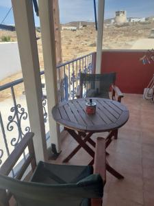 a table and chairs on a balcony with a table and chairs at A Lodge in Tinos Town