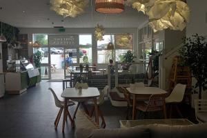 a restaurant with tables and chairs in a room at Sunny holiday house in Newquay