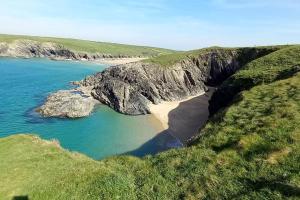 an aerial view of a beach with rocks and water at Sunny holiday house in Newquay +6 photos