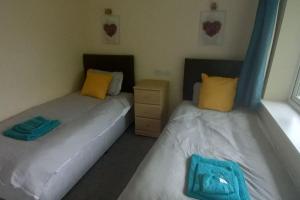 two beds sitting next to each other in a room at Sunny holiday house in Newquay