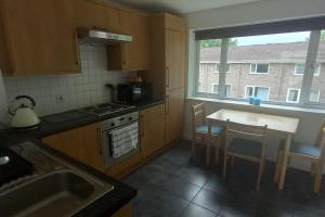 a kitchen with a sink and a stove and a window at Sunny holiday house in Newquay