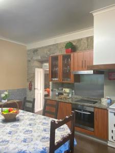 een keuken met houten kasten en een tafel met een aanrecht bij Casa do Carqueijo in Vila Praia de Âncora