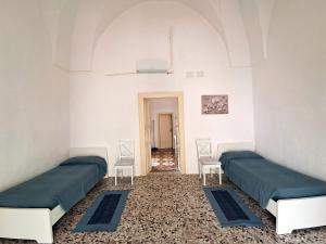 a room with two beds and two chairs in it at Mescia Giuditta Dimora Rustica Salentina in Felline