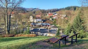 a park bench on a hill overlooking a town at miniSowa in Jedlina-Zdrój
