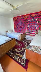 a room with three beds and a colorful wall at Panphilove 23 in Cholpon-Ata +17 photos