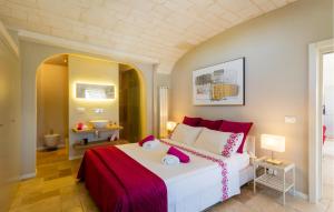 a bedroom with a large white bed with red accents at 2 Bedroom Cozy Home In Ostuni in Ostuni