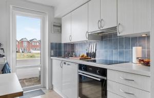 a kitchen with white cabinets and a stove top oven at Apartment No 195 in Sønderby